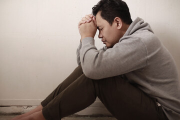 Obraz premium Sad depressed anxiety Asian man thinking contemplating bad thing happened in his life, stress exhausted feeling down expression, financial or relationship problem