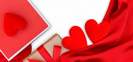 Wooden white background with red hearts and red satin. Concept of valentine day.