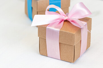Gift box wrapped with pink ribbon on white wood background