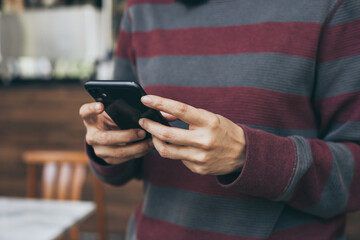 using cell phone hand holding mobile texting message contact us.chatting,search internet information in office.technology device communication connecting