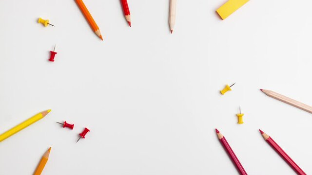 Red and yellow pen, sticky note, notepad, marker, eraser, push pins, paper clip pencils on white background. Stop motion animation flat lay top view Education back to school online study copy space