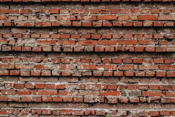 The texture of an old brick wall with natural defects. Scratches, cracks, crevices, chips, dust, roughness, abrasion. Template for design and background.Copy space