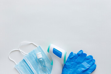 Corona virus protection concept flat lay. Non-contact infrared body thermometer, latex gloves,...