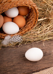 Chicken eggs in basket on wooden background