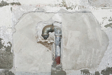 Metal water pipe. Old house plumbing system background. Grunge rusty steel pipe. Iron piping in the wall. Plumber background. Empty copy space pipe. Closeup pipeline. Bathroom renovation background.
