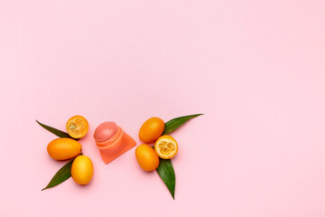 Natural lip balm with citrus fruit on color background