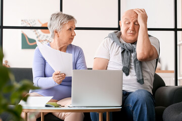 Stressed senior couple in debt at home