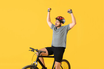 Happy male cyclist on color background