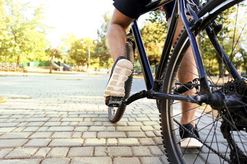 Naklejka premium Male cyclist riding bicycle outdoors, closeup