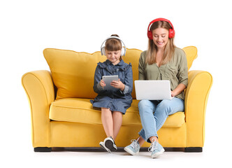 Mother and daughter with gadgets on sofa against white background