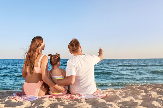 Happy Family Sitting On Sea Beach