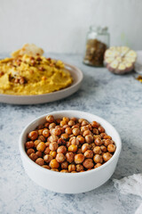 Leblebi Turkish delicacy of fried chickpeas in porcelain plate in kitchen, vertical food content, selective focus
