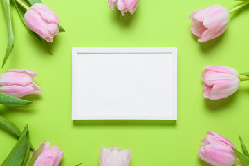 Beautiful flowers and empty frame on color background