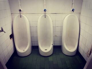 The interior of old dirty Public toilet urinals in men toilet with very bad conditions