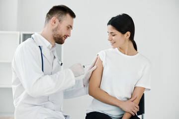 Fototapeta premium doctor injecting covid-19 vaccine into female patient's shoulder