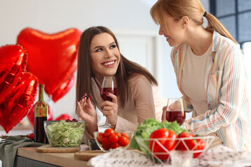 Happy transgender couple celebrating Valentine's Day while cooking festive dinner at home