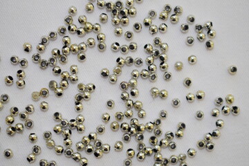 Gray beads scattered on a white background. Materials for needlework.