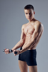 Fototapeta na wymiar athletic man with an inflated torso dumbbells in hands exercise 
