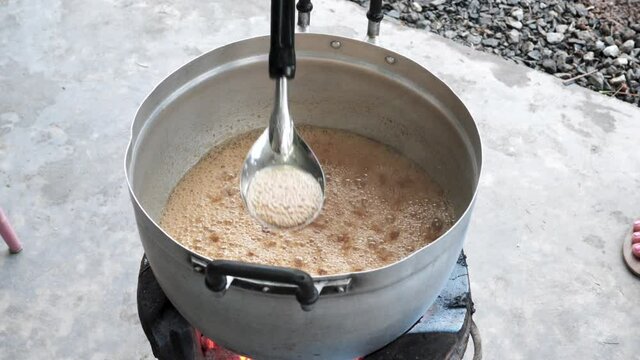 Top view outdoor kitchen, chef mixes boiling tamarind sauce - Thailand dish