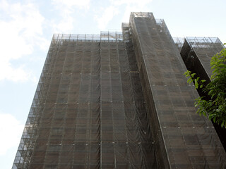 足場が組まれシートで覆われた改築中のビル