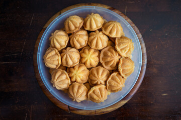 Kuih Bahulu, baulu or bolu in a container. Sponge cake baked in special aluminium moulds is the Asian tradition food in popular Malaysia and Indonesia.