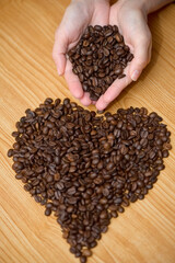 Coffe beans in hands and coffee beans in heart shape 