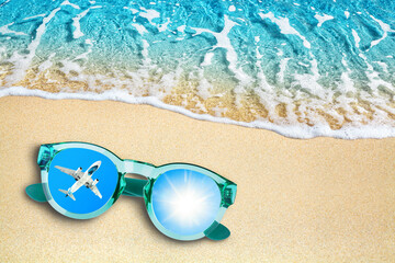 Fototapeta na wymiar Blue sea wave, sand beach, turquoise ocean water, sunglasses, mirror reflection of airplane flight and shiny sun in sky top view close up, summer holidays relax, tropical island vacation, travel banne