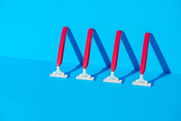 Disposable razors on blue background, studio shot