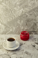 A white cup of coffee on a grey background. Hot drink concept. Coffee shop, espresso, copy space