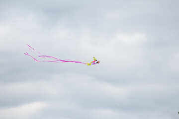 pink kite flying high in the sky on a rainy and windy day