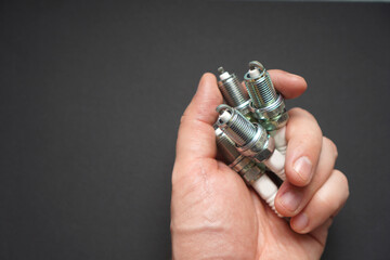 Automobile spark plugs in a man's hand. Background with copy space.