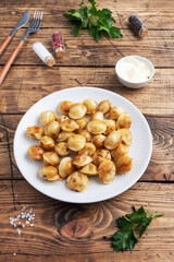 Traditional fried pelmeni, ravioli, dumplings filled with meat on plate, russian kitchen. Wooden rustic table, copy space.