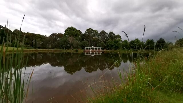 Beautiful time lapse video of a pond with stunning reflections of trees and slow moving clouds on water, Fagan Park, Dural, Sydney, New South Wales, Australia
