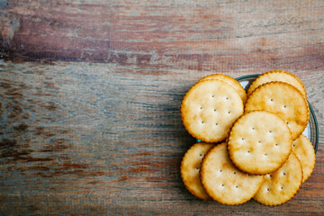 Round salted cracker cookies in wooden bowl putting