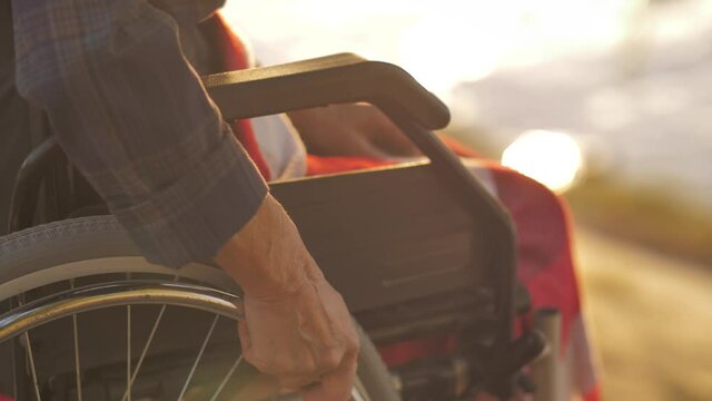 Hand takes the wheel of a wheelchair