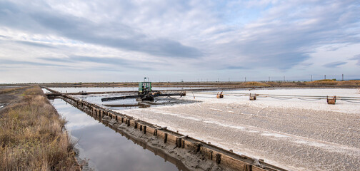 Machine gathering salt on Pomorie salt lake in Bulgaria. Harvesting sea salt