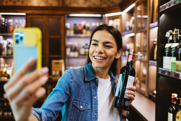 Happy young woman holding bottle of wine