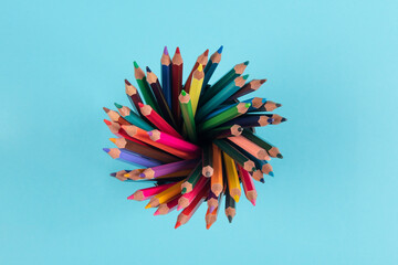 Top view of color pencils isolated on blue background
