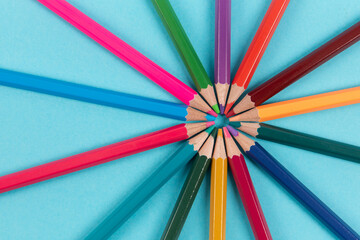 Fototapeta premium Circle made of colorful pencils on blue background