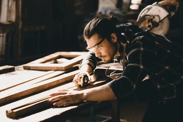 Deurstickers Carpenter man attend to making masterpiece woodworks handcrafted furniture fine measure in wood workshop. © Quality Stock Arts