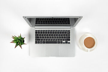 White office desk table with laptop computer, cup of coffee and office supplies. Top view with copy space, flat lay.