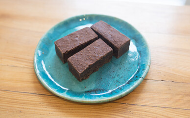 Chocolate brownies on blue plate. Homemade bakery and vegan sweet dessert.