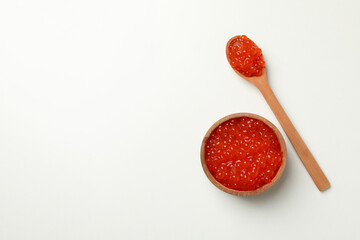 Wooden bowl and spoon with caviar on white background, space for text
