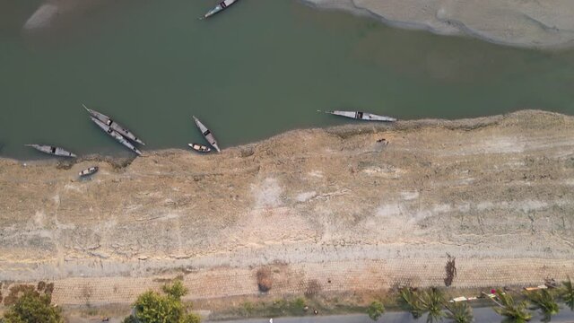 Aerial drone video Bangladesh village. Village Road, green trees, river and boats.Bird's eye view of Bangladesh village. Aerial shot of bangladesh padma river.South Asia village aerial shot