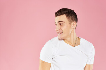 Emotional man gesturing with his hands white t-shirt pink isolated background