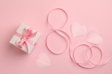 8 made of ribbon, hearts and gift box on pink background