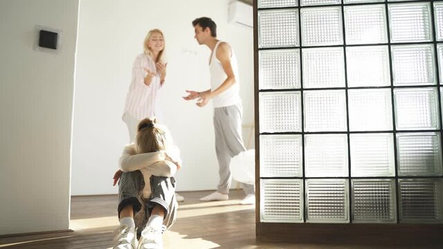 Girl is frustrated with psychological problems caused by mom and dad dispute, crying on the floor.