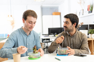 Healthy food in the workplace concept. Two coworkers having lunch in the office.