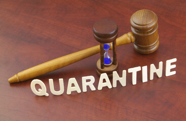 Wooden gavel with hourglass and word quarantine. Lockdown and quarantine time concept.