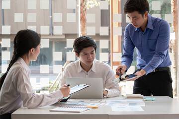 Business men and woman meeting conference in office. Professional people group working and discuss strategy using laptop, tablet computer, and documents at desk. Business brainstorming concept.